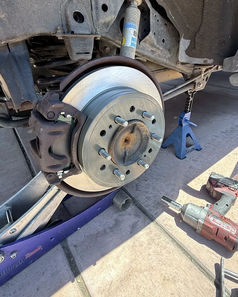 Freshly installed rotor and caliper on a mobile brake repair