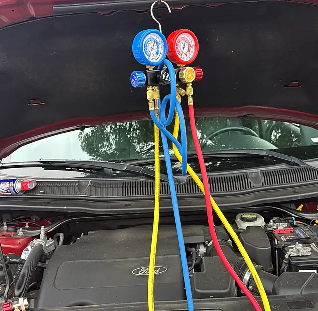 A/C manifold gauges hooked up to a Ford SUV during mobile A/C diagnostics